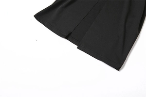 Détail de la robe noire à taille haute montrant les coutures et la fente latérale