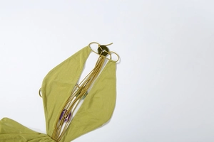Détail d'une robe verte dos nu avec licou orné d'anneaux décoratifs colorés