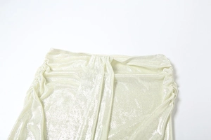 Détail du tissu métallique doré champagne froncé montrant une texture chatoyante et des plis