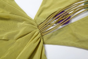 Détail d'une robe en mesh vert avec centre froncé et perles décoratives en résine