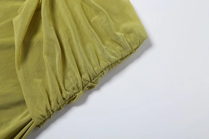 Détail du tissu en maille vert avocat avec bords à volants et texture transparente