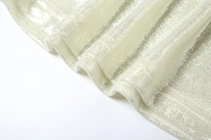 Détail du tissu métallique scintillant avec des paillettes champagne et tissage texturé