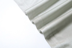 Détail du tissu en maille côtelée vert sauge montrant une couture double aiguille soignée