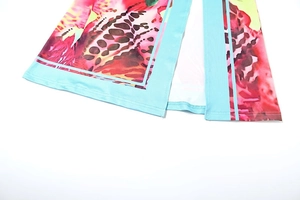 Close-up of tropical floral print skirt hem with light blue contrast piping and side slit