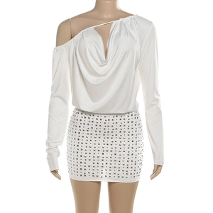 Detailed view of white backless dress with long sleeves and silver stud embellishments