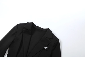 Dettaglio del classico rever a lancia e della tasca su un blazer nero strutturato