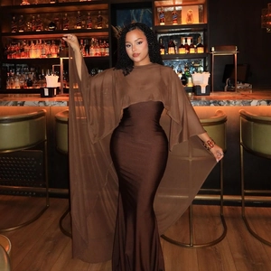 Detail of elegant slim-fit brown maxi dress with a flowing sheer chiffon cape