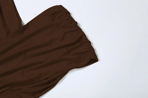 Détail macro du tissu froncé élastique marron et des coutures de qualité sur la robe