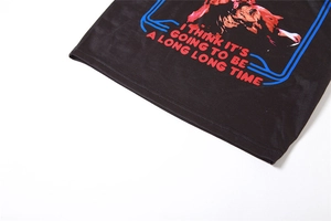 Detail of black printed t-shirt with quality stitching and vintage graphic text