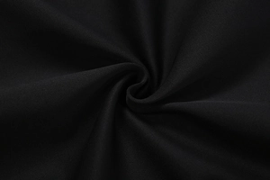 Vista macro che mostra la morbida trama e il drappeggio opaco del tessuto tessile nero