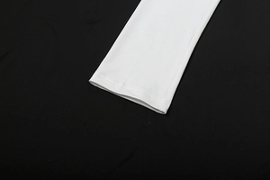 Detail shot of clean double-stitched hem and white knit fabric texture on dress