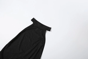 Detailed view of black polka dot backless romper featuring a halter neckline and fabric texture