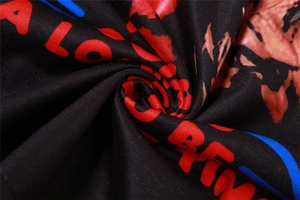 Macro detail of black knit fabric showing bold red and blue printed letters and texture