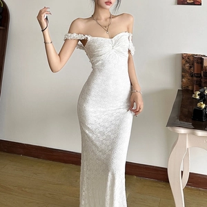 Détail de la robe longue en dentelle blanche avec motifs floraux et fines bretelles