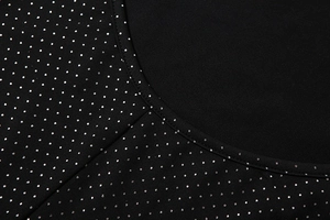 Detail of black knit fabric with silver glitter polka dots and neat neckline stitching