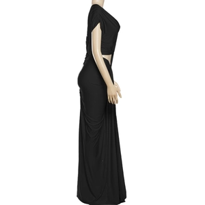 Détail de la robe longue noire moulante avec fente latérale et tissu drapé plissé
