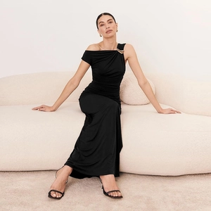 Détail d'une robe noire asymétrique froncée avec anneau métallique doré élégant