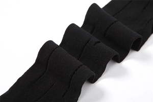 Dettaglio della fine trama a maglia e del design a rete traforata di questi pantaloni neri