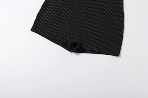 Detailed view of black polka dot fabric showing premium elastic texture and print quality