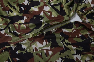Dettaglio del tessuto mimetico verde militare con cerniera in resina e cuciture precise