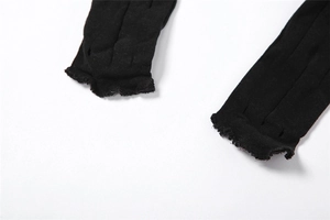 Dettaglio macro dei leggings in maglia nera con bordi a taglio vivo e trama verticale