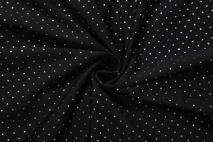 Detail of black knit fabric with silver rhinestone dots showing texture and shimmer