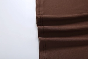 Detailed close-up of brown knit dress hem showing precise double-needle stitching and texture