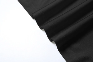 Détail de la texture en maille côtelée noire avec un éclat soyeux subtil et des lignes verticales