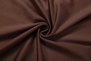 Macro shot of dark brown knit fabric showing sophisticated texture and drape of the dress