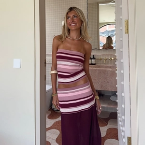 Detail of striped tube top and sheer mesh skirt set in pink and burgundy tones