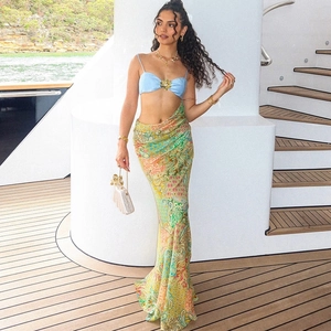 Detail of blue bikini top with gold flower buckle and paisley print maxi skirt