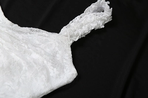 Détails de dentelle florale blanche et finitions délicates sur la bretelle de la robe