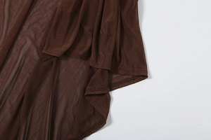 Detailed macro shot of the double-needle hem on a sheer brown mesh shawl dress