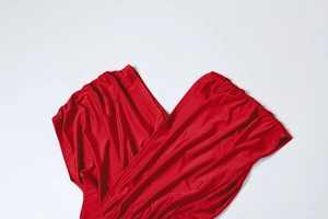 Gros plan d'une robe rouge avec col en V croisé et détails drapés élégants