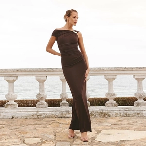 Détail de la robe asymétrique marron chocolat avec ornement métallique en forme de galet