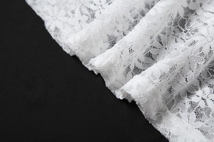 Gros plan sur le tissu en dentelle blanche à motifs floraux et broderies ajourées de luxe