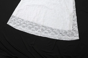 Détail de l'ourlet en dentelle florale blanche avec bords festonnés sur une robe