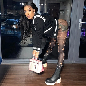 Giacca da baseball nera con leggings in rete traforata e borsa a mano rosa alla moda
