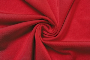 Vue macro du tissu côtelé rouge au drapé fluide pour une robe longue ajustée sexy