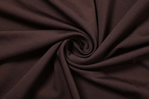 Vue macro d'un tissu en maille marron foncé avec des plis drapés et une texture douce