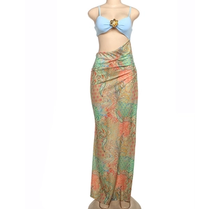 Detail of blue halter top with gold flower accent and paisley print maxi skirt