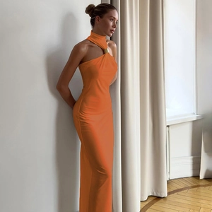 Detail of elegant orange halter neck maxi dress with gold ring collar and slim fit fabric
