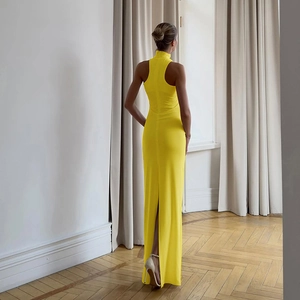 Detail of elegant yellow slim-fit maxi dress featuring high neck and sexy back slit design