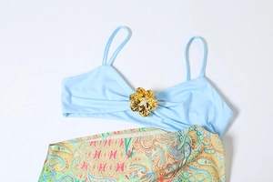 Detail of light blue bikini top featuring a 3D gold flower and paisley print bottom