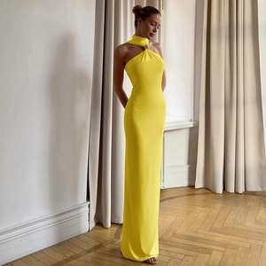Detail of elegant yellow halter neck maxi dress featuring a gold metal ring neckline detail