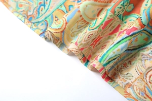 Close-up of paisley pattern fabric showing fine ribbed texture and dual-needle stitching
