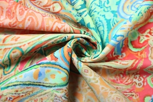 Macro shot of vibrant paisley pattern fabric with detailed knit texture and rich colors