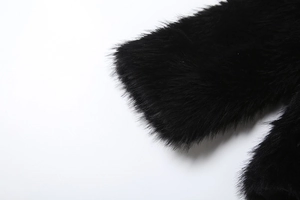 Detailed macro view of black faux fur texture on the sleeve of a winter coat
