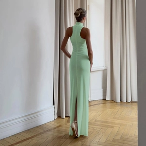 Detailed back view of a slim mint green halter dress showing the cutout and center slit