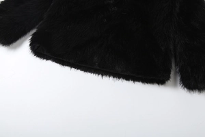 Close-up of black faux fur jacket hem and cuffs showing soft fluffy texture